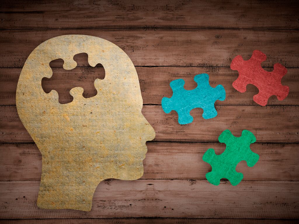 Human face and a Jigsaw Puzzle on brown wood